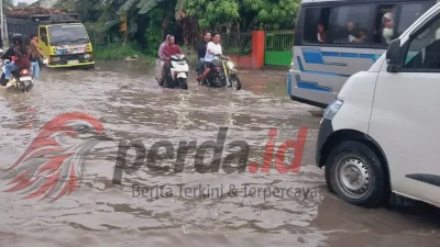 Kondisi jalan rusak parah di jalur lintas Perdagangan – Pematang Siantar yang digenangi air dan lumpur.